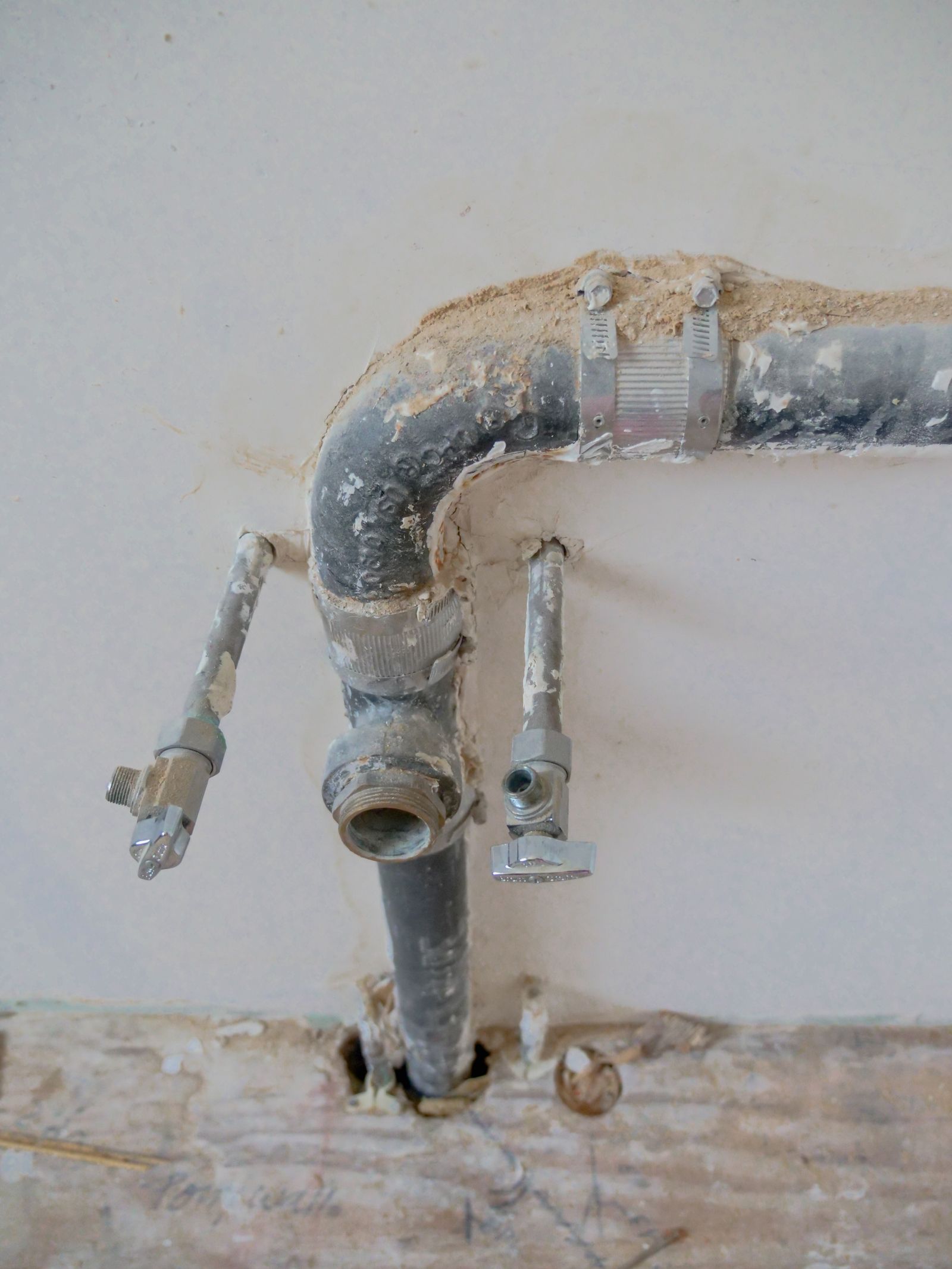 Waterleidingen en afvoer in een open muur tijdens een reparatie